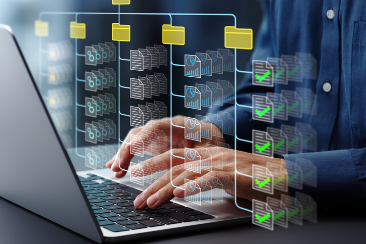 Document management system DMS. Folder structure and classification system. File and folder icons. Businessman using laptop computer for controlling document versions.