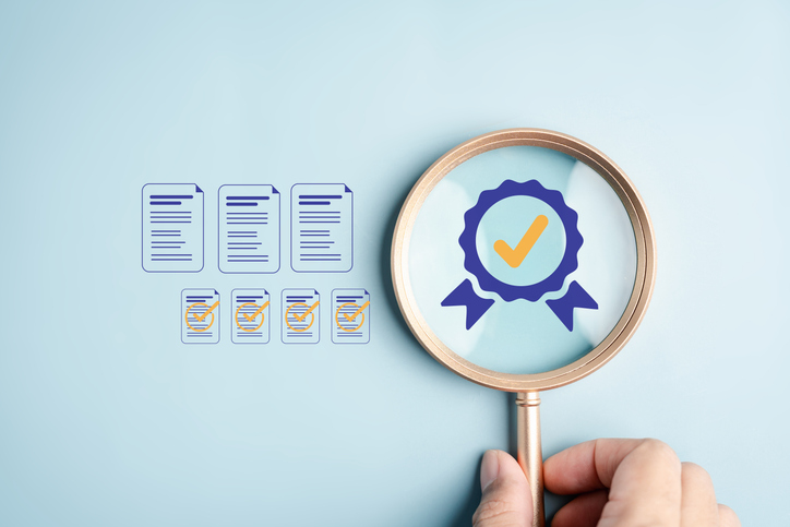 Quality document check verification process with a magnifying glass focusing on approved documents and certification symbol, illustrating inspection, audit, and compliance concept.