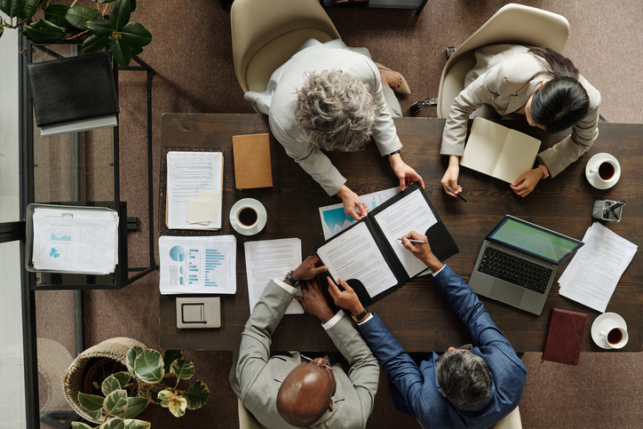 Multiethnic Middle Aged Executives Discussing Documents during Office Brainstorming